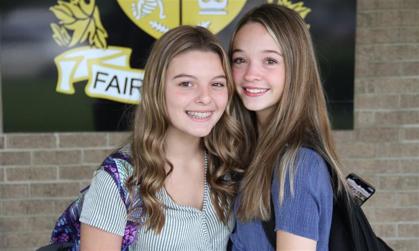 Two students smile